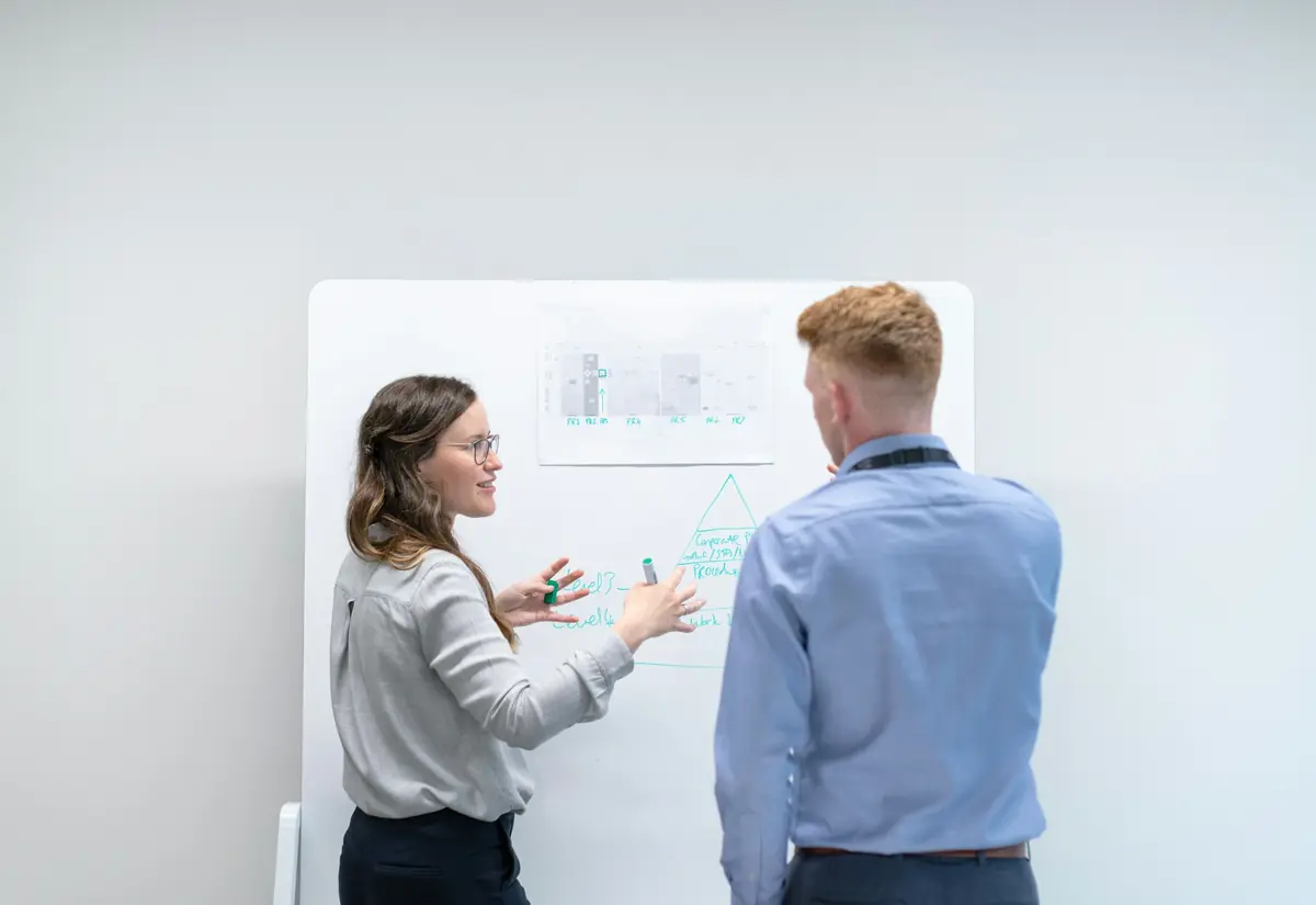 Due colleghi discutono uno schema strategico alla lavagna